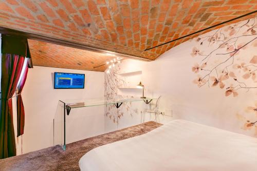 a bedroom with a bed and a brick ceiling at Il Convento Dei Fiori Di Seta in Bologna