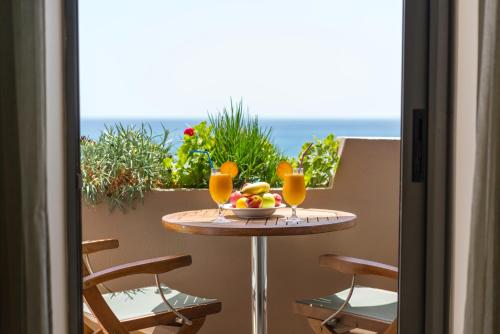 
a dining room table with chairs and a vase of flowers at Alianthos Beach Hotel in Plakias
