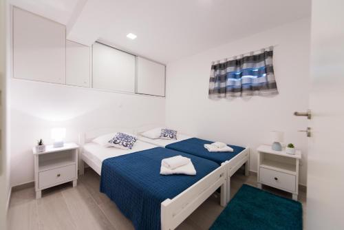 a white room with two beds and two night stands at Apartman Ante in Split