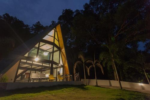 a house with a large window on the side of it at Bamboo Garden House in Laem Sing