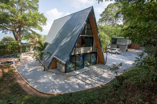 a small house with a metal roof on a lot at Bamboo Garden House in Laem Sing