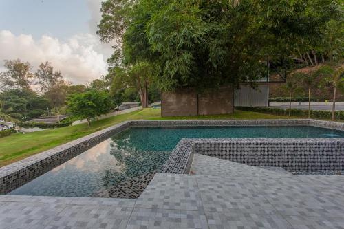 a swimming pool with a tile floor and a tree at Bamboo Garden House in Laem Sing