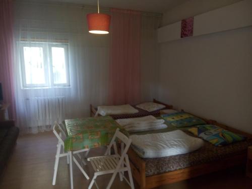 sypialnia z dwoma łóżkami, stołem i oknem w obiekcie Pokoje Rybacka 5 w mieście Krynica Morska