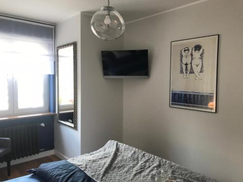 - une chambre avec un lit et une télévision murale dans l'établissement Apartament 27, à Gdynia