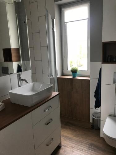 a bathroom with a white sink and a window at Apartament 27 in Gdynia