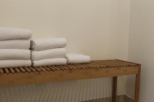 a pile of towels sitting on a wooden bench at Amalie Bed and Breakfast & Apartments in Odense
