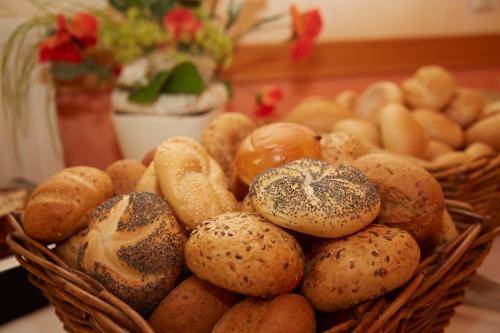 a basket of different types of bread on a table at Flairhotel Hubertus in Bad Zwischenahn