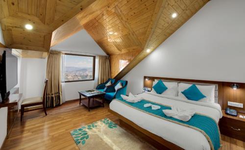 a bedroom with a large bed with blue accents at Hotel The Twin Towers in Shimla