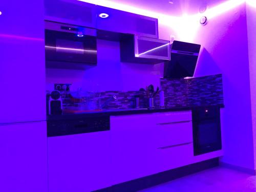 a purple kitchen with a stove and a sink at Quartier Naturiste Colline 4 in Cap d'Agde
