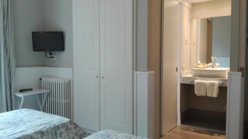 een kleine slaapkamer met een wastafel en een spiegel bij Hotel Xalet la Coromina in Viladrau