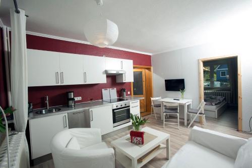 アーレンスホープにあるFerienwohnung Meerzeitのキッチン、リビングルーム(白い家具付)が備わります。