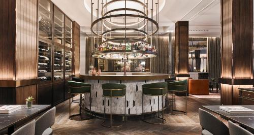 a bar in a restaurant with a chandelier at Gran Hotel Inglés - The Leading Hotels of the World in Madrid