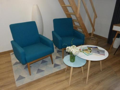 dwa niebieskie krzesła i stół w pokoju w obiekcie B&B Lily et Paul w mieście Bédoin