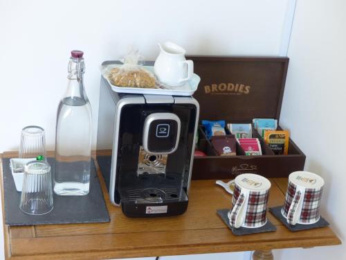 a toaster sitting on a wooden table next to a bottle at Urquhart Bay B&B in Drumnadrochit