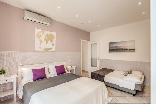 リド・ディ・オスティアにあるRome4Guest Ostiaのホテルルーム 紫色の枕付きベッド2台付
