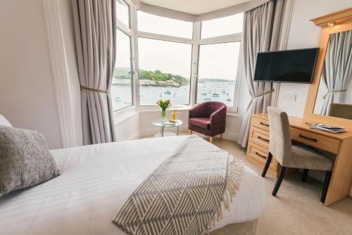a hotel room with a bed and a desk and a window at Greenbank Hotel in Falmouth