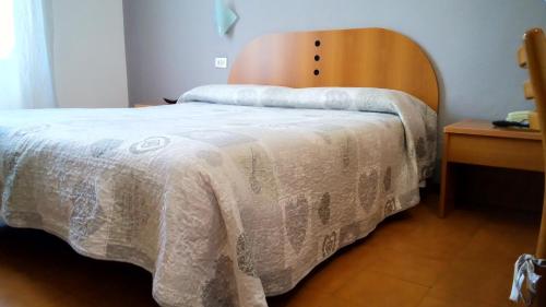 a bedroom with a bed with a wooden head board at Hotel Tirreno in Milan