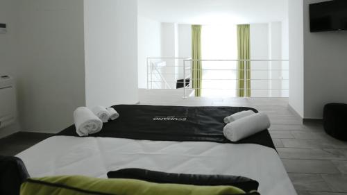 a bed with a black and white comforter in a room at Ecumano Space in Naples