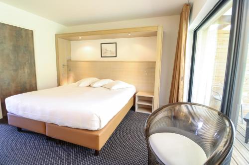 a hotel room with a bed and a chair at Loire & Sens in Juigné-sur-Loire