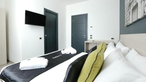 a bedroom with a white bed with a yellow tie on it at Ecumano Space in Naples