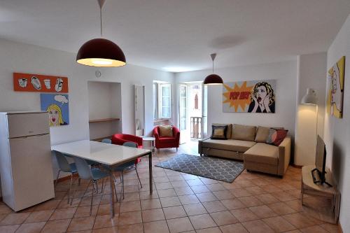 uma sala de estar com um sofá e uma mesa em Pop Art Apartment em Torri del Benaco