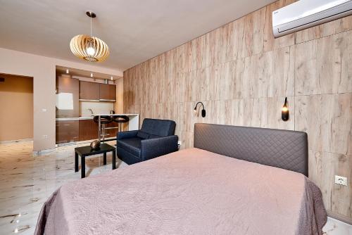 ein Schlafzimmer mit einem Bett und einem Stuhl in der Unterkunft Apartments Magic in Pomorie