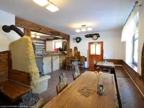 salon z drewnianym stołem i kuchnią w obiekcie Penzion Pod Ozvěnou w mieście Teplice nad Metují