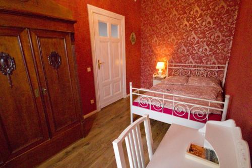 Schlafzimmer mit einem Bett, einem Tisch und einer Tür in der Unterkunft Ferienwohnung Babelsberg in Potsdam