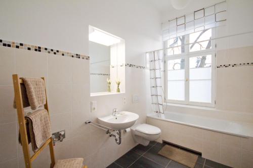 ein Bad mit einem Waschbecken, einem WC und einem Fenster in der Unterkunft Ferienwohnung Babelsberg in Potsdam