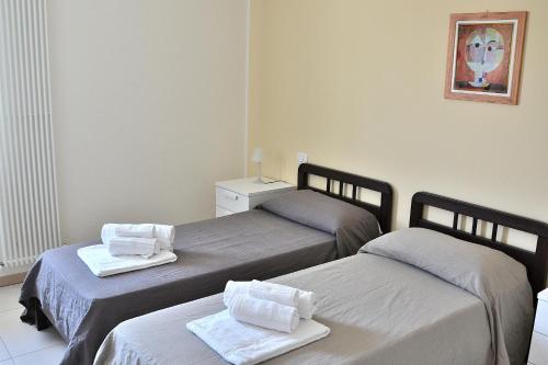 a room with two beds with towels on them at Cà Gardesana With Pool in Garda