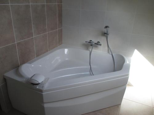 a white bath tub with a faucet in a bathroom at Hôtel Le Saint Martin in Sablé-sur-Sarthe