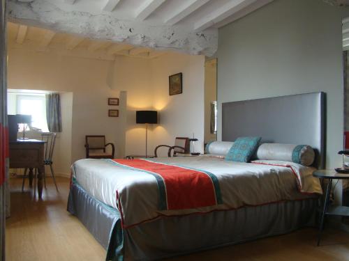 ein Schlafzimmer mit einem großen Bett in einem Zimmer in der Unterkunft Manoir de la Ville Marie in Hirel