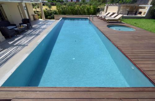 basen z drewnianym tarasem i basen w obiekcie Geraniotis Villa w mieście Gerani