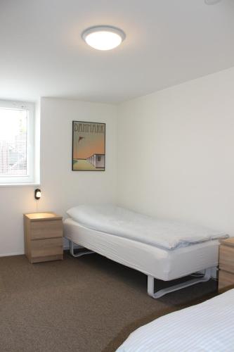 a white room with a bed and a window at Amalie Bed and Breakfast & Apartments in Odense
