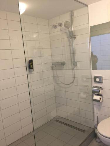 prysznic ze szklanymi drzwiami i toaletą w obiekcie Hotel Central Hannover w Hanowerze