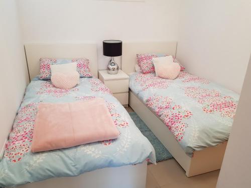 1 dormitorio con 2 camas con sábanas rosas y azules en Las Terrazas De La Torre Apartment, en Roldán