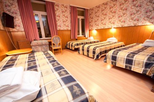 Pokój hotelowy z 2 łóżkami i krzesłem w obiekcie Hotelli Iisalmen Seurahuone w mieście Iisalmi
