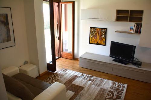 a living room with a couch and a flat screen tv at Dream Apartment in Toscolano Maderno
