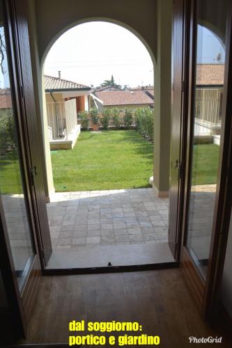 an open door to a patio with a view of a yard at Dream Apartment in Toscolano Maderno