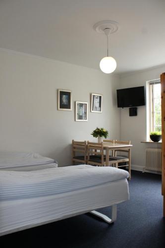 a hotel room with two beds and a table and a tableablish at Amalie Bed and Breakfast & Apartments in Odense