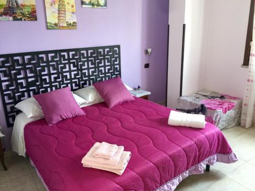 a bedroom with a purple bed with towels on it at Da Francesca in Scilla