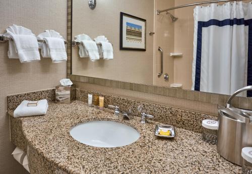 a bathroom with a sink and a shower and a mirror at Hotel 24 South in Staunton