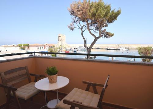 uma varanda com uma mesa, cadeiras e uma árvore em Lungomare em Marciana Marina