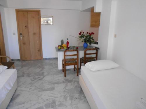 a living room with two beds and a table with a table at Artemis Hotel Apartments in Hersonissos
