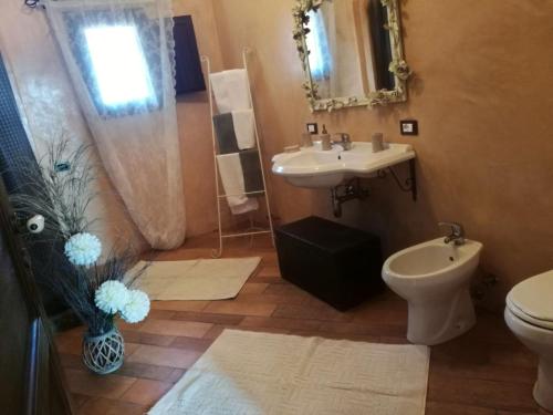 bagno con lavandino, servizi igienici e specchio di Dammuso Mueggen a Pantelleria