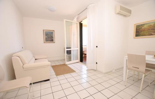 Sala de estar blanca con silla y mesa en Lungomare, en Marciana Marina