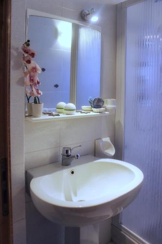a bathroom with a white sink and a mirror at Villa Carina in Massa