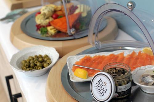 a table with a plate of food and a sink at Relais Le Chevalier in Rīga