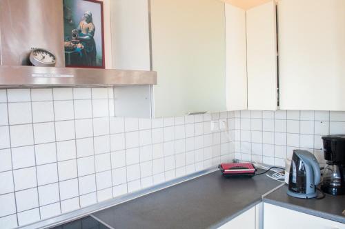 a kitchen with white tiled walls and a counter at Stan&Family in Kalavárda
