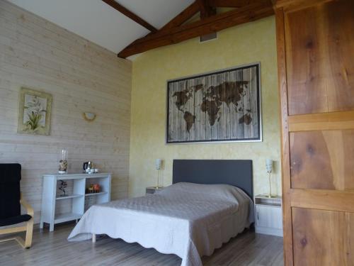 a bedroom with a bed and a map on the wall at La Lauriére in Treize-Vents